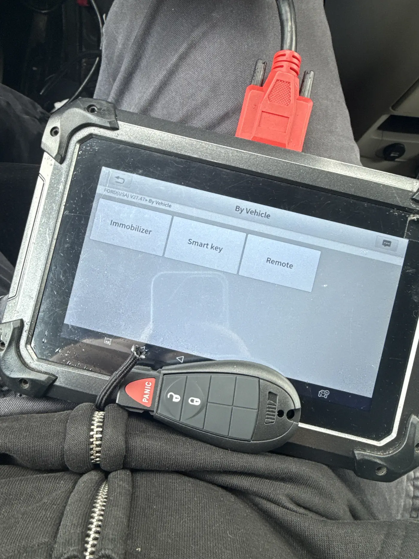 Locksmith cutting and programming a replacement car key on site in Hamilton